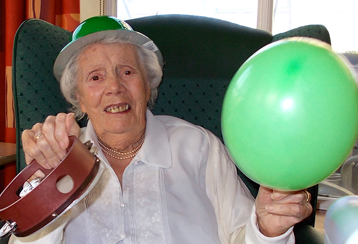 Photo of elder holding a balloon and tamborine